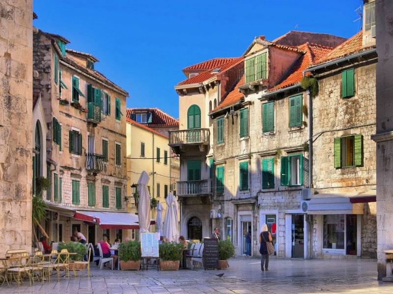 Der historische Platz Braće Radić (Obstplatz) in der Altstadt von Split mit dem venezianischen Turm, dem Milesi-Palast und dem Marko-Marulić-Denkmal.